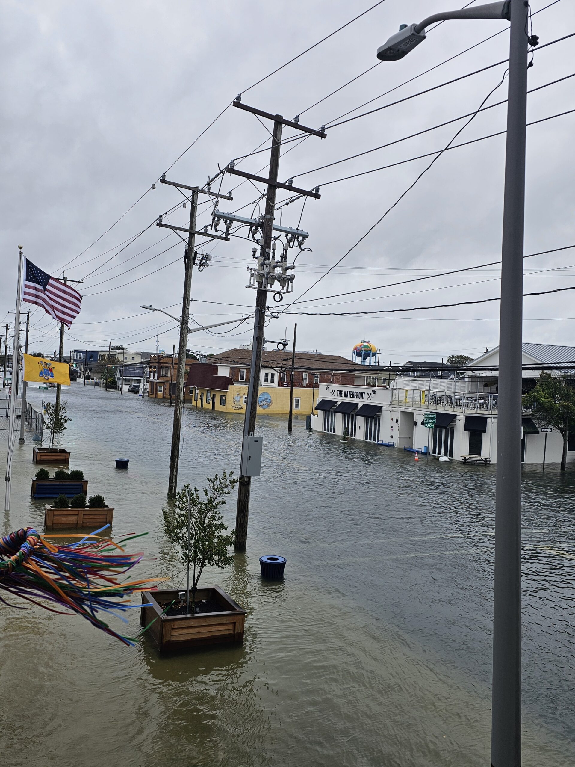 Floodwater covering a street and sidewalks near buildings in Wildwood, New Jersey.