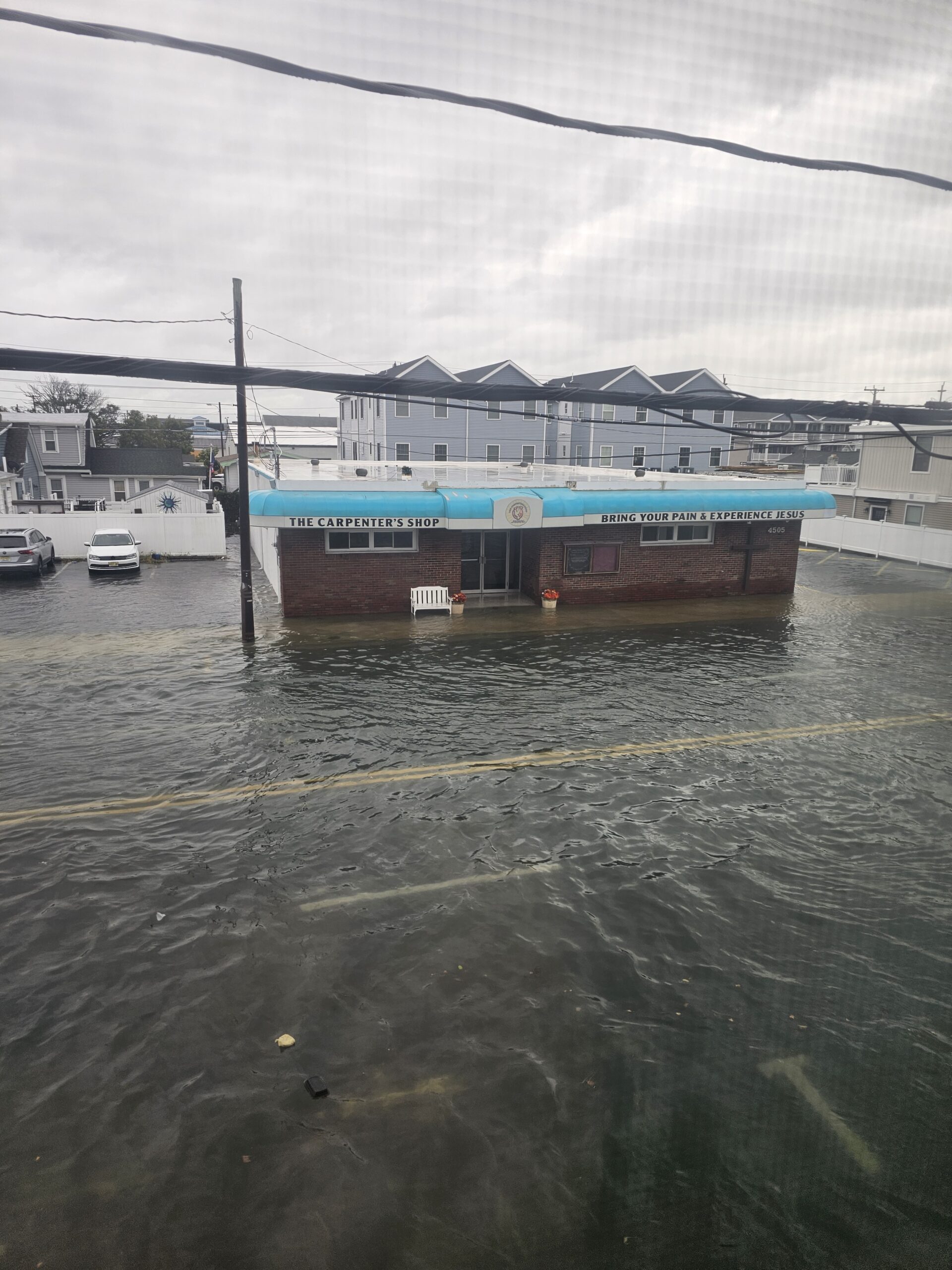 Floodwater covering the roadway outside a brick building in Wildwood, New Jersey.