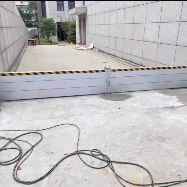 Aluminum flood barriers installed across a building access ramp in Naples Florida